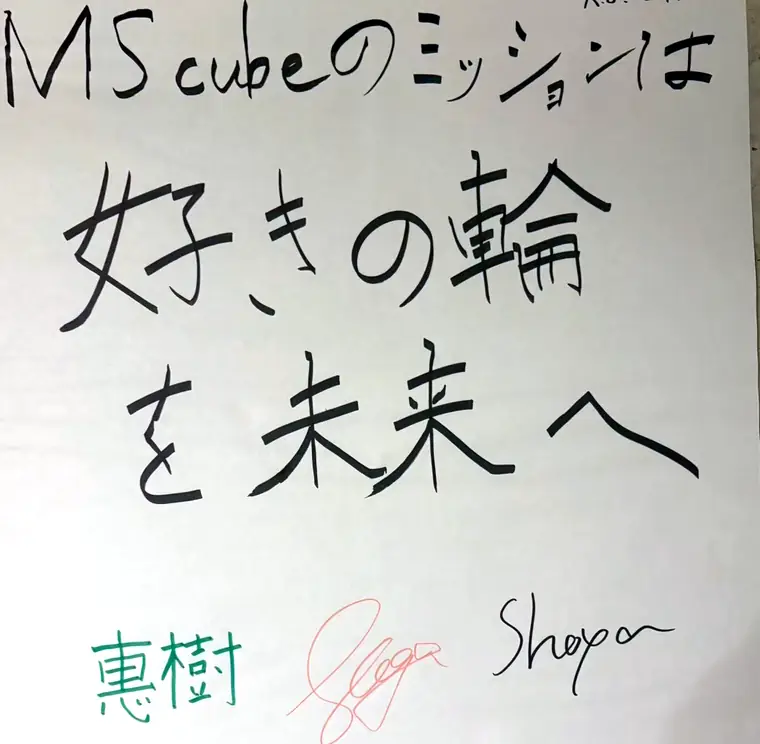 手書きの紙。「MScubeのミッションは 好きの輪を未来へ」と三人の署名